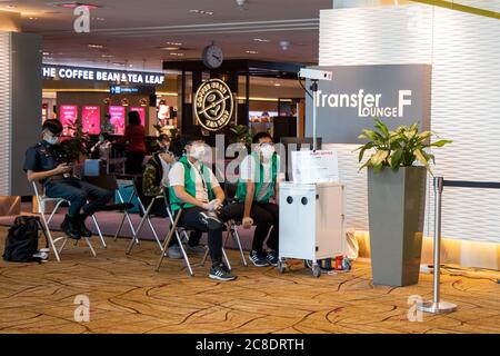 SINGAPOUR - JUILLET 21. 2020: Le personnel de l'aéroport de Changi est assis derrière une caméra infrarouge à un poste de contrôle de la température dans la zone passagers de l'aéroport de Changi Banque D'Images