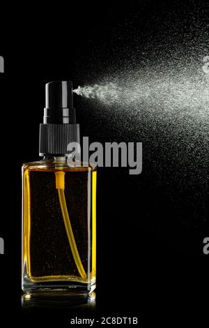 bouteille de parfum pulvérisé sur fond noir Banque D'Images