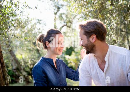 Joyeux couple adulte du milieu de l'année à déguster dans un verger d'olive Banque D'Images