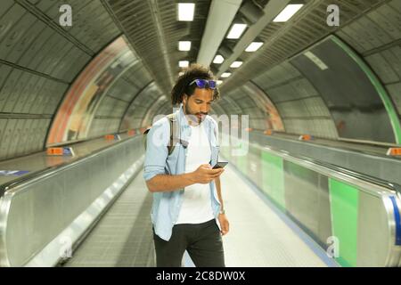 Portrait d'un jeune homme regardant un téléphone mobile, Londres, Royaume-Uni Banque D'Images