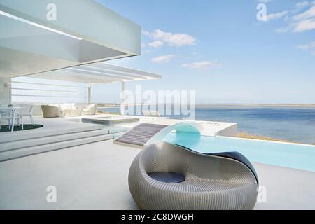 Fauteuil design au bord de la piscine d'une maison de plage de luxe Banque D'Images
