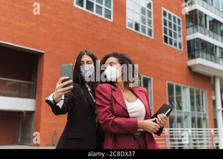 Femmes d'affaires prenant le selfie en ville pendant le coronavirus Banque D'Images