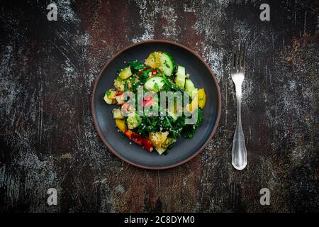 Assiette de salade végétalienne chaude avec quinoa, épinards, poivrons, tomates, concombres, menthe et persil Banque D'Images