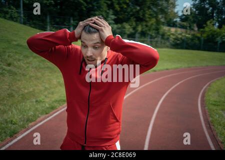 athlète épuisé reposant sur la piste après la course ou l'entraînement en plein air Banque D'Images