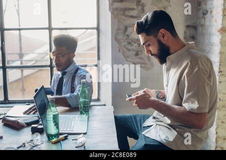 Hommes d'affaires créatifs travaillant à table dans le bureau de loft Banque D'Images