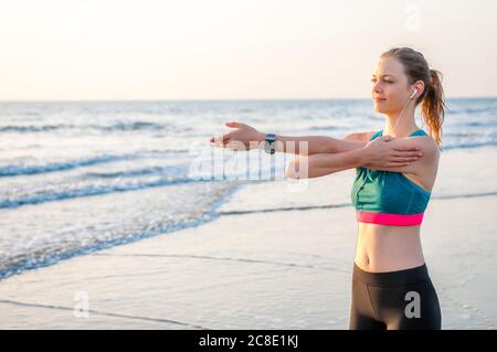 Femme sportive s'étendant à la mer au lever du soleil, Gran Canaria, Espagne Banque D'Images