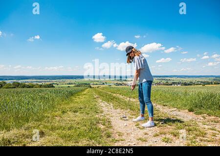 Jeune femme jouant au golf à la campagne Banque D'Images