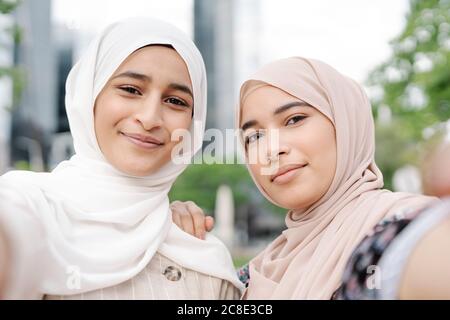 Les sœurs musulmanes prennent le selfie en ville pendant la journée ensoleillée Banque D'Images