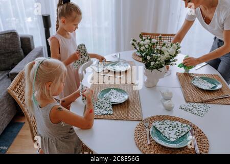 La mère avec ses filles s'est mise à table à manger à la maison Banque D'Images