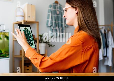 Femme de mode travaillant à la maison assis au bureau avec tablette Banque D'Images