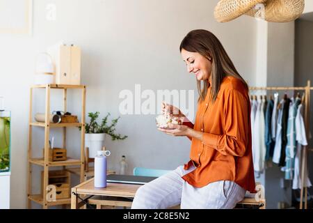 Femme de mode ayant une pause déjeuner dans le bureau à la maison Banque D'Images