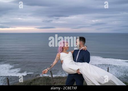 Couple de mariée sur le point de vue et l'océan en arrière-plan Banque D'Images