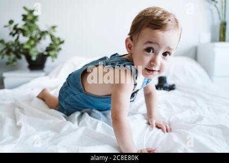 Baby Girl crawling on bed Banque D'Images