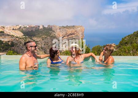 Amis pendant la fête au bord de la piscine Banque D'Images