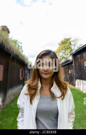 Jeune femme asiatique belle au milieu de vieux chalets en bois alignés Banque D'Images