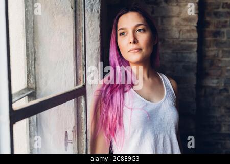 Portrait d'une jeune femme élégante aux cheveux roses lissage Banque D'Images