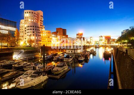 Allemagne, Rhénanie-du-Nord-Westphalie, Dusseldorf, Bateaux amarrés dans le canal de la ville au crépuscule Banque D'Images