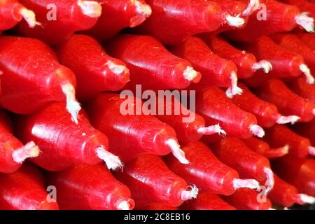 Vue en angle d'une pile de bougies en cire rouge. Banque D'Images