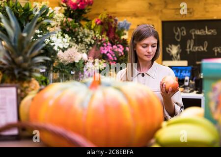 Femme achetant des fruits à l'épicerie Banque D'Images