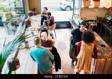 Rendez-vous entre amis dans un restaurant chic, parlant au bar Banque D'Images