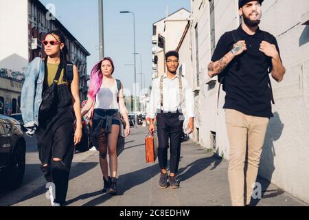 Groupe d'amis marchant sur le trottoir de la ville Banque D'Images