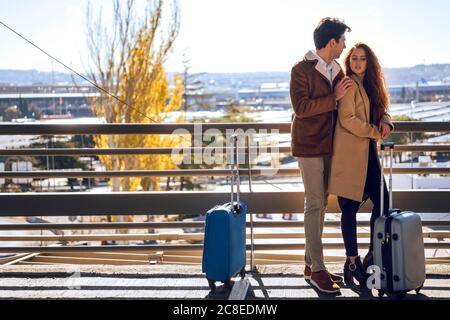 Couple d'affaires romantique debout sur une passerelle surélevée à l'aéroport Banque D'Images