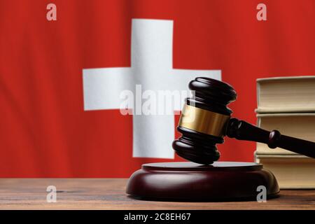 Justice et justice dans la Confédération suisse. Juge Hammer sur fond de drapeau suisse. Banque D'Images