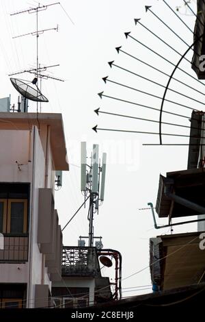 Environnement urbain thaïlandais montrant une tour de réception de téléphone cellulaire, des antennes tv et des éléments de logement urbain à Bangkok, en Thaïlande. Banque D'Images