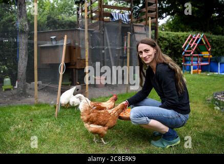 Berlin, Allemagne. 17 juillet 2020. Vanessa Janßen, propriétaire de poulet, nourrit ses poulets. Dans le jardin de Vanessa Janßen de Berlin-Rudow il n'y a pas de poulets pedigree se grattant et pecking depuis l'été 2019, mais six poulets hybrides, des races croisées de différentes races avec de bonnes performances de ponte. (À «après le jardinage urbain les poulets viennent») Credit: Britta Pedersen/dpa-Zentralbild/dpa/Alay Live News Banque D'Images