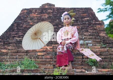 Une fille asiatique vêtue de costumes traditionnels avec un parapluie en papier, un célèbre artisanat dans le nord de la Thaïlande. Banque D'Images