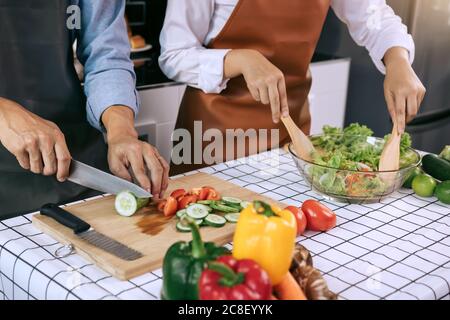 Deux jeunes couples asiatiques s'aident les uns les autres et apprécient la cuisine. Banque D'Images