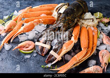 Délicieux poissons et fruits de mer frais sur fond sombre vintage. Poisson, palourdes et crevettes aux herbes aromatiques, épices et légumes - alimentation saine, régime o Banque D'Images