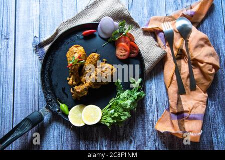 Tikka de poulet sur une casserole avec condiments Banque D'Images
