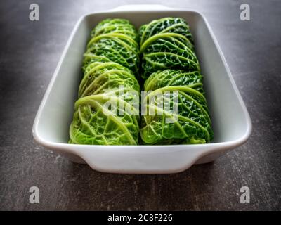 Feuilles de chou frisé farcies de boulettes de viande dans un plat de cuisson en céramique blanche. Vue aérienne. Banque D'Images