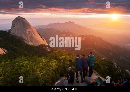 SEOUL, Corée - 28 juin 2015 : Photographe prend une photo du lever du soleil le matin sur la montagne Bukhansan , Séoul, Corée du Sud. Banque D'Images