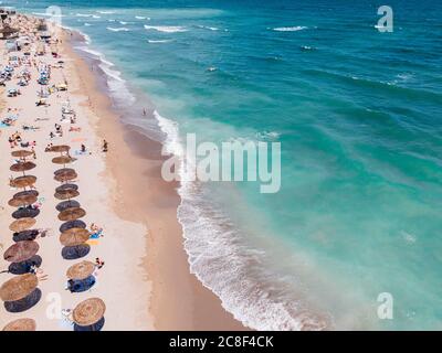 Plage aérienne, personnes et parasols colorés sur la photo de plage, paysage de l'océan bleu, vagues de mer Banque D'Images