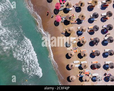 Plage aérienne, personnes et parasols colorés sur la photo de plage, paysage de l'océan bleu, vagues de mer Banque D'Images