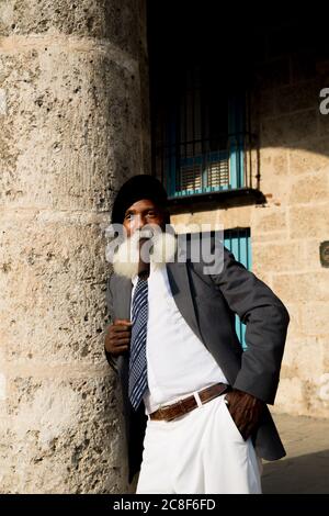 La Havane / Cuba - 04.16.2015: Afro cuban vieux avec une longue barbe blanche portant un costume et un béret militaire noir, fume un gros cigare Banque D'Images