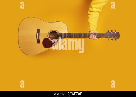 guitare à la main sur fond jaune, image maquette Banque D'Images