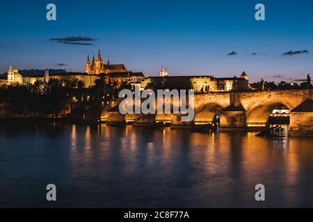 Pont Charles à Prague la nuit, traversant la Vltava avec la cathédrale Saint-Vitus et le château de Prague Cityscape Banque D'Images