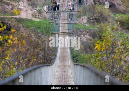 Le village troglodyte de Khndzoresk est relié par un pont suspendu de 160 m de long et de 36 m de haut. Le village est dans le sud-est de l'Arménie. Banque D'Images