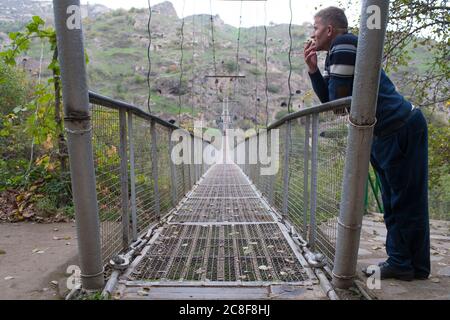 Le village troglodyte de Khndzoresk est relié par un pont suspendu de 160 m de long et de 36 m de haut. Le village est dans le sud-est de l'Arménie. Banque D'Images