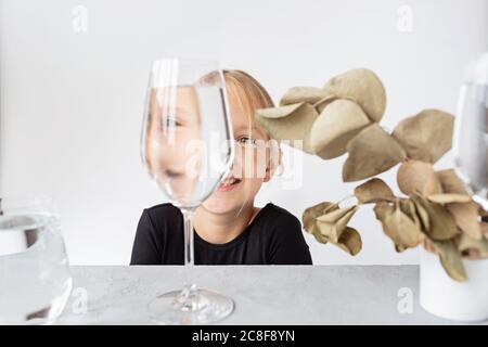 Portrait d'enfant de mode, l'œil regarde à travers le verre de l'eau. Distorsion d'objet, illusion optique concept. Art contemporain minimaliste Banque D'Images