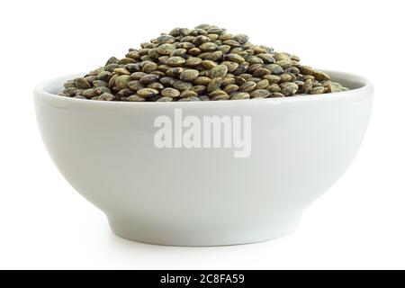 Lentilles vertes sèches du puy dans un bol en céramique blanc isolé sur blanc. Angle bas. Banque D'Images