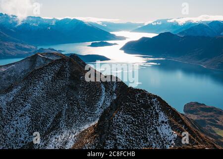 La lumière du soleil reflète l'eau du lac Wanaka, vue de Roys Peak, Nouvelle-Zélande Banque D'Images