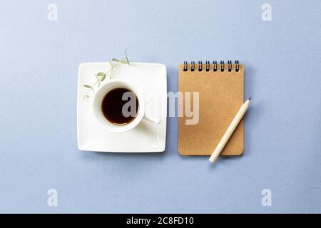 Carnet et café noir sur fond bleu. plan, vue de dessus, espace de copie. Lieu de travail et d'étude Banque D'Images