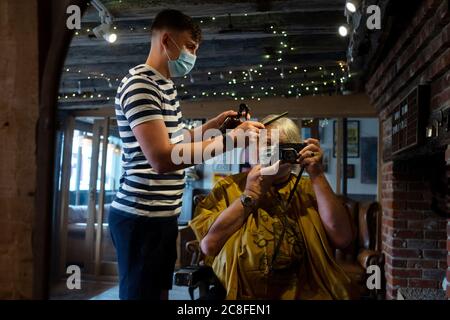 Thaxted, Royaume-Uni. 24 juillet 2020. Thaxted Essex UK port obligatoire de masques pour le visage en ayant coupé les cheveux le 24 juillet 2020 au salon de coiffure et salon de coiffure de «Ladles and Jellycuillers» de Thaxted, Jordan coupe les cheveux des photographes pour la première fois en plus de quatre mois en raison du blocage du coronavirus. A partir d'aujourd'hui en Angleterre, tous les clients et le personnel des coiffeurs, cafés, bars, magasins et restaurants sont obligés par la loi de porter des masques ou de risquer une amende de £100. Le photographe est sorti modèle. Photo par crédit: BRIAN HARRIS/Alay Live News Banque D'Images