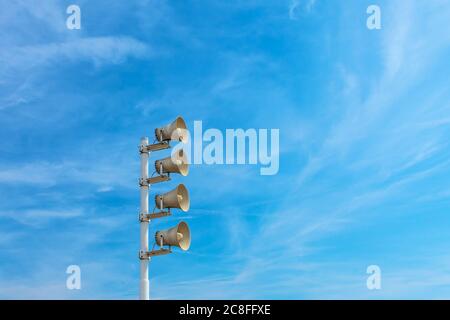 Rangée de mégaphones extérieurs contre un ciel bleu Banque D'Images