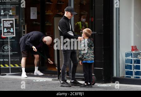 Leicester, Leicestershire, Royaume-Uni. 24 juillet 2020. Un garçon a un masque mis sur avant d'entrer dans un magasin de chaussures après que les restrictions locales de verrouillage de coronavirus ont été assouplies. Les magasins non essentiels peuvent rouvrir dans la zone verrouillée, même si le gouvernement a déclaré que tous les déplacements à l'intérieur, à l'extérieur et à l'intérieur de la ville sont toujours interdits. Credit Darren Staples/Alay Live News. Banque D'Images