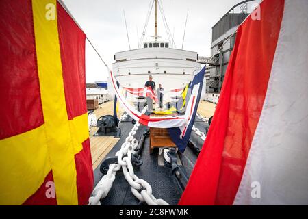 Rab McAulay (à gauche) et Tony Smith, de l'équipe d'entretien, lèvent les drapeaux habrisés sur le yacht royal Britannia pour marquer la réouverture de l'attraction touristique d'Édimbourg aux membres du public le lundi 27 juillet. Banque D'Images
